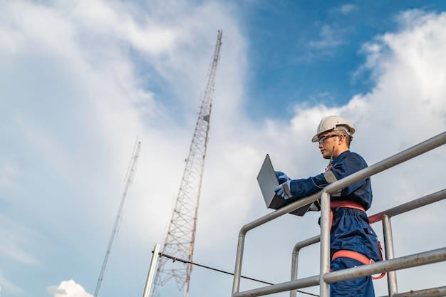 A close-up shot of a technician working on telecommunications equipment atop a cell tower in a rural setting. The focus is on the worker's hands and the intricate details of the hardware, emphasizing the technical expertise required for such installations.