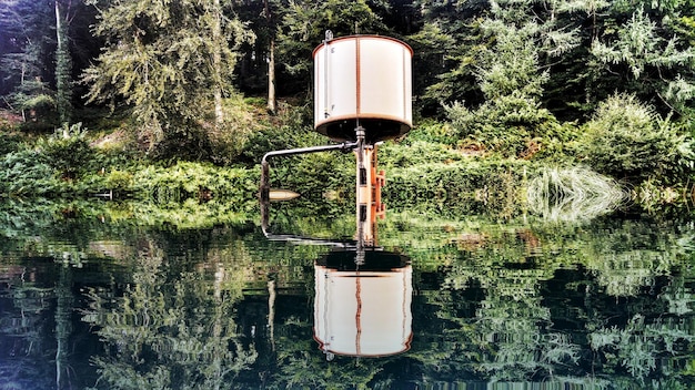 A pristine river flowing through a lush green valley, with a subtly visible water sampling device in the foreground, representing water quality monitoring.