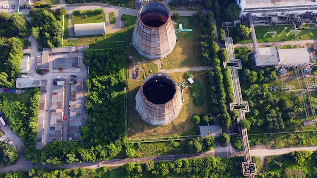 An aerial view of a modern nuclear power plant with steam rising from cooling towers, surrounded by lush green landscapes, suggesting clean energy production.