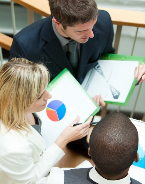 Business professionals in a meeting room, using charts and diagrams to discuss financial strategies and adjustments in response to economic changes.