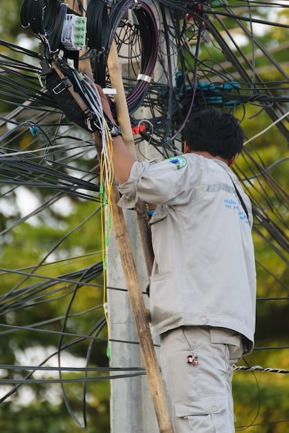 Technicians installing fiber optic cables in a rural community, with modern equipment, symbolizing infrastructure expansion efforts to bridge the digital divide.