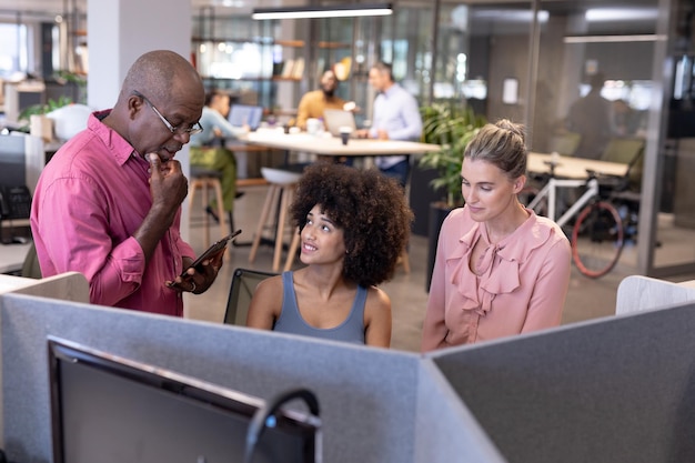 A diverse group of tech workers in a modern office collaborating, some on computers, others discussing, symbolizing the internal operational changes and increased team efforts required for DSA compliance.