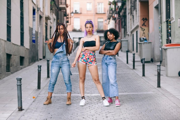 A diverse group of young adults on a city street, each wearing distinct 90s-inspired outfits demonstrating a mix of grunge, minimalist, and preppy styles with modern accessories, captured with a slightly grainy, nostalgic film effect.