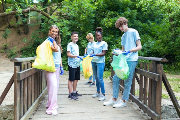 A diverse group of community volunteers engaged in a river cleanup project, wearing bright vests and gloves, collecting trash along a lush riverbank, conveying community involvement in environmental conservation.