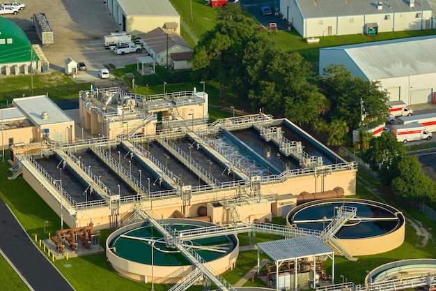 A state-of-the-art water treatment plant, with clear, filtered water visible in settling tanks, surrounded by green infrastructure and solar panels, symbolizing advanced water management.