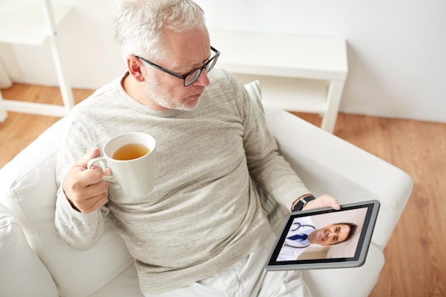 An older adult learning how to use a tablet for a telemedicine appointment, with a younger person patiently assisting them, representing the effort to bridge the digital literacy gap. The setting is home-like and reassuring.